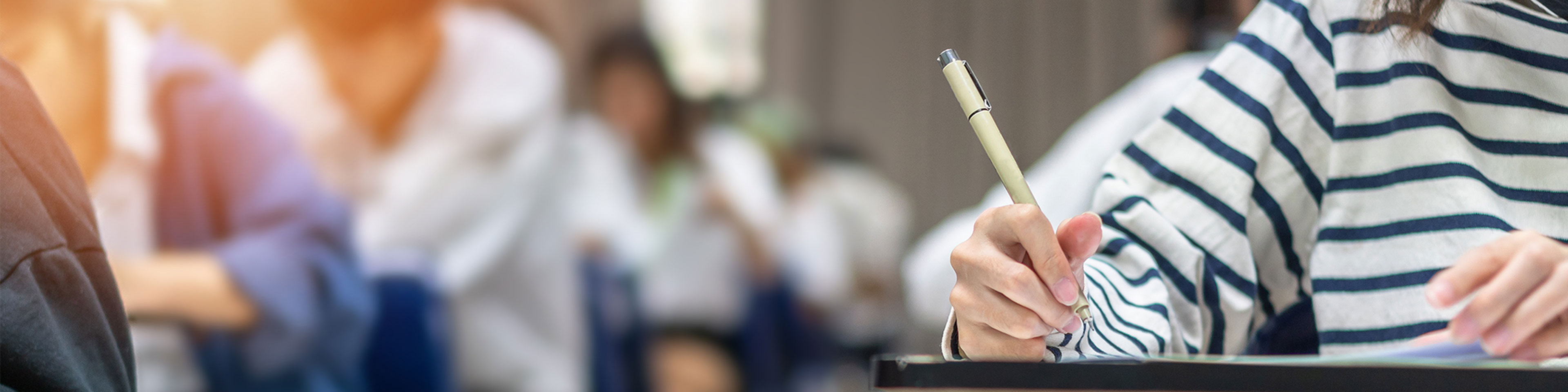 une personne répond à un examen sur une feuille de papier.