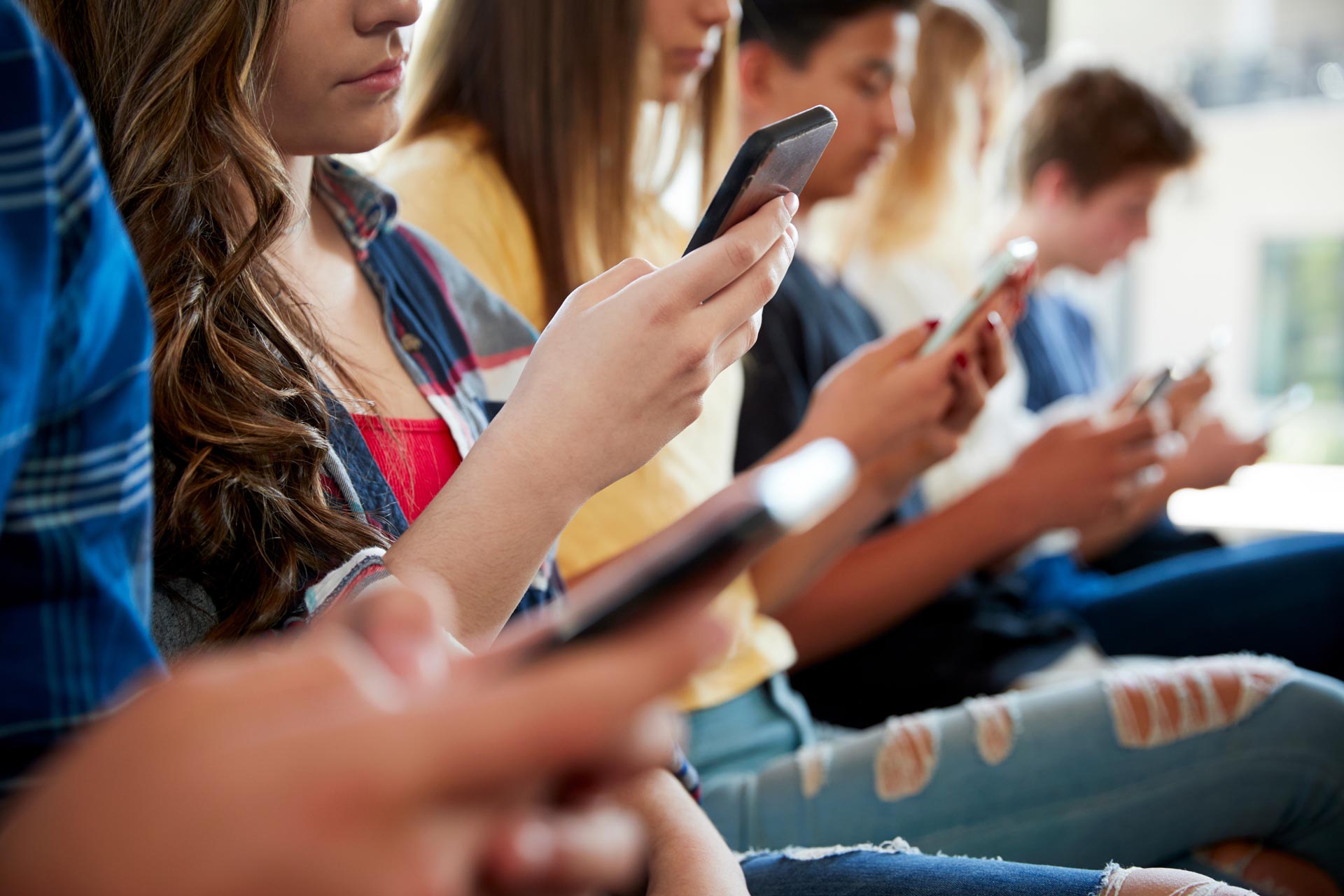 cellulaires-etudiants Personnes étudiantes qui regardent leur téléphone cellulaire